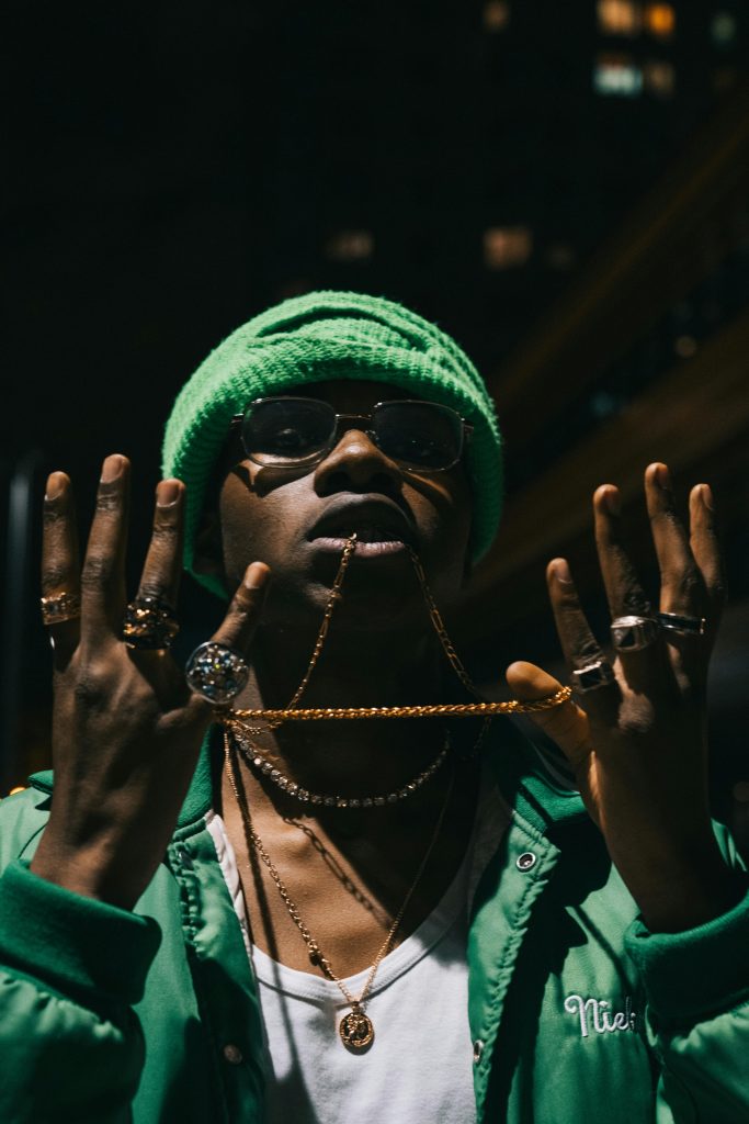 Hip Hop Jewelry Showcase: Cuban link chains and rings on model in urban night scene.